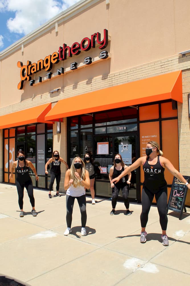 orange theory team working out outside with masks